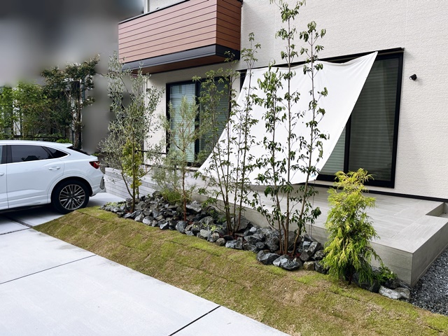 LABOT::台形のタイルテラスと植栽が映えるオープン外構の家
